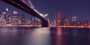 a beautiful photo of the city shot beneath a bridge.